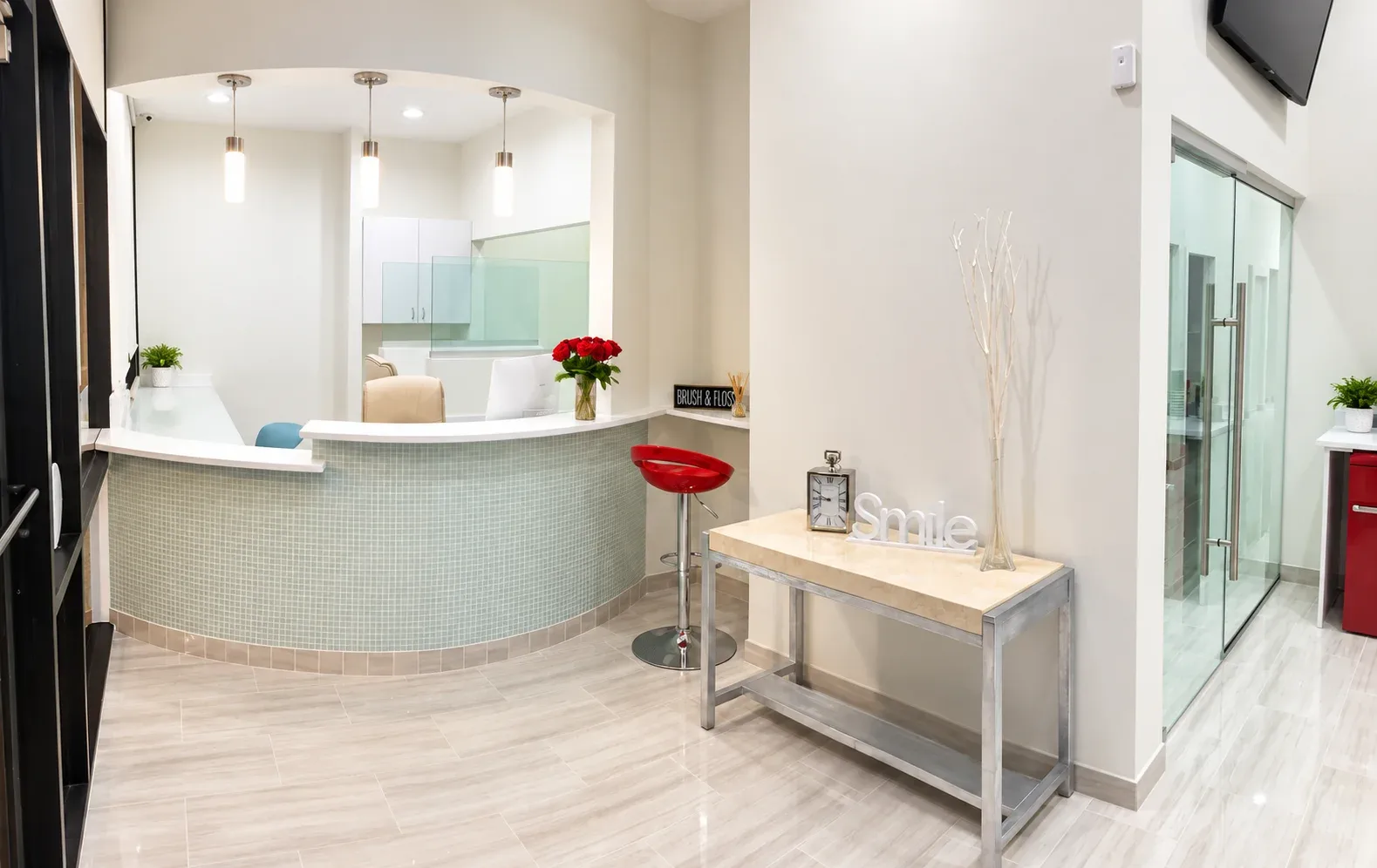 Front desk with red stools and a Smile sign on the counter