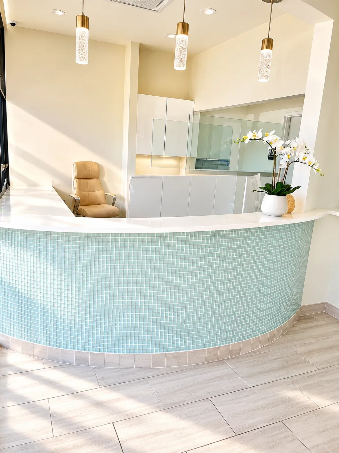Curved reception desk with teal mosaic tile and pendant lights