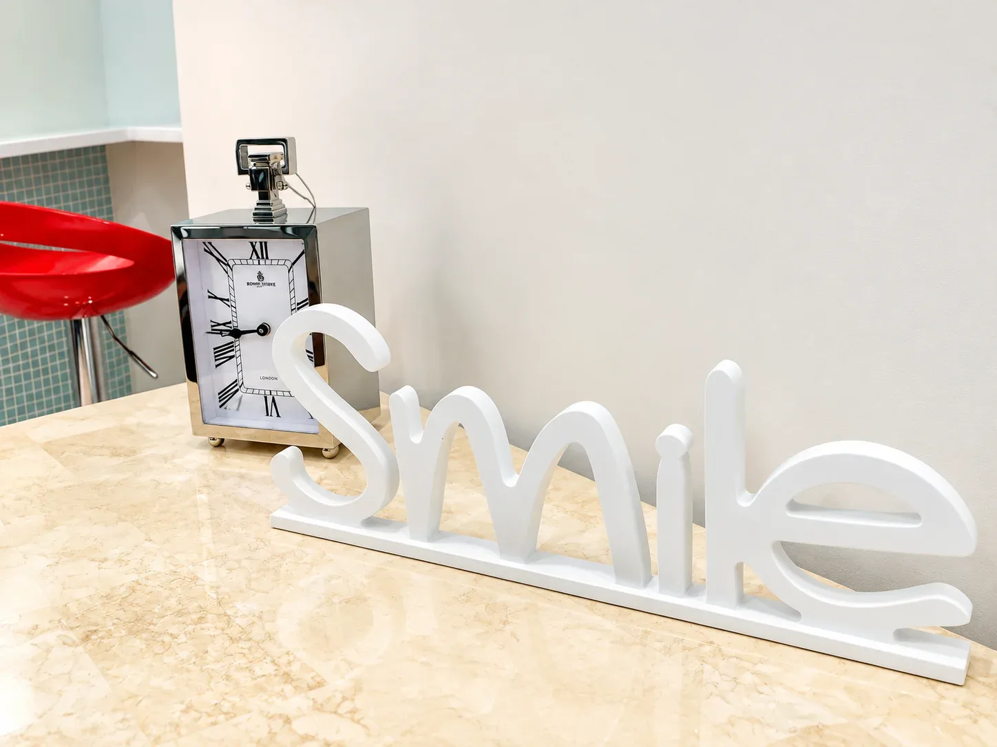 White Smile sign and clock on the marble front counter